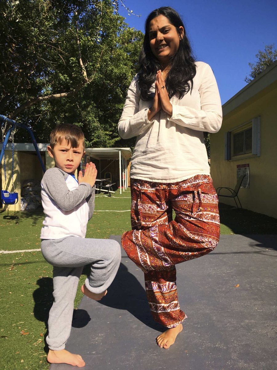 A. Vaani Maharaj-Raghubir teaching tree pose with a young student
